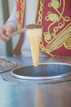 Sweet ice cream cone being served in a vibrant market stallの写真素材
