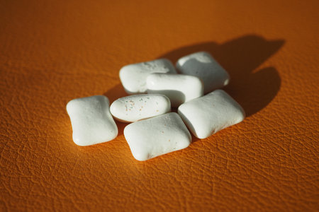 White gum pieces on orange surface in natural lightの写真素材