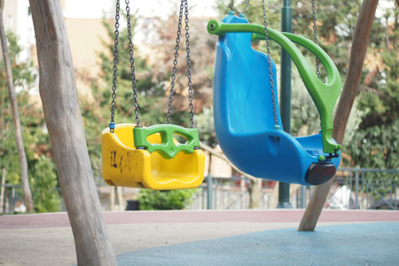Colorful swings in a vibrant playground on a sunny dayの写真素材