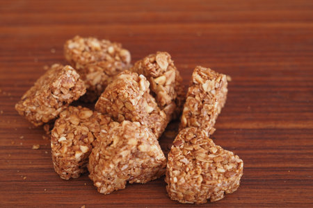 Granola squares arranged on a wooden surface for healthy snackingの写真素材
