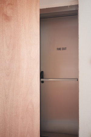 Fire exit door partially opened in a modern building hallwayの写真素材