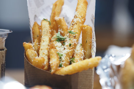 Delicious golden fries with herbs served in a rustic containerの写真素材