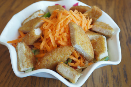 Delicious salad with crispy chicken and fresh carrots at lunchtimeの写真素材