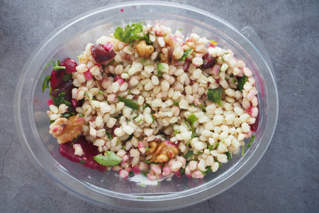 Delicious salad with walnuts and pomegranate on a marble tableの写真素材