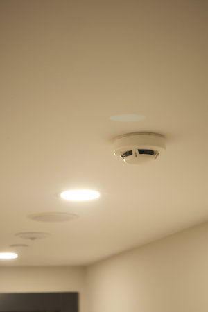 Smoke detector and ceiling lights in a modern interior spaceの写真素材