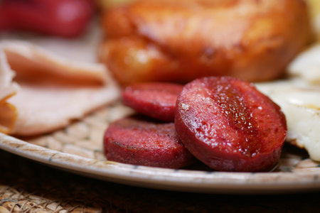 Delicious grilled sausage served on a rustic plate during breakfastの写真素材