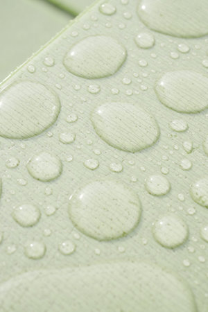 Droplets of water collect on a smooth surface in soft lightの写真素材