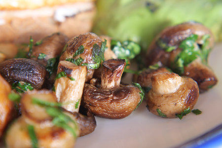 garlic mushrooms garnished with herbs on a plateの写真素材