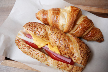 Freshly baked croissant and sandwich filled with ham and cheeseの写真素材