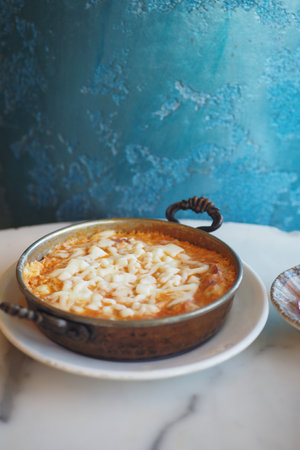 Traditional turkish menemen served in rustic pottery on a marble tableの写真素材