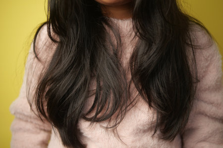 little girl with Long dark hair flowing over a soft sweaterの写真素材