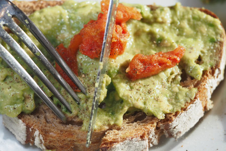 Fresh avocado toast topped with sun-dried tomatoesの写真素材