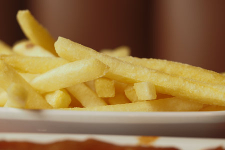 Golden fries served on a white plate in a casual settingの写真素材