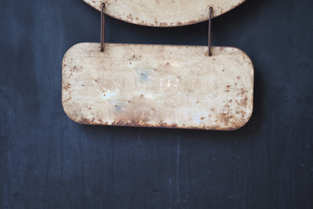 Rusty metal sign hanging on a textured wall in historic locationの写真素材