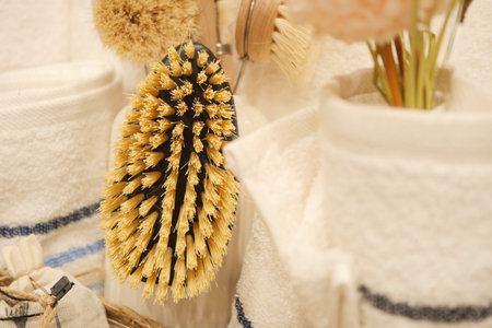 Natural cleaning brush displayed in a bathroom setting with towelsの写真素材