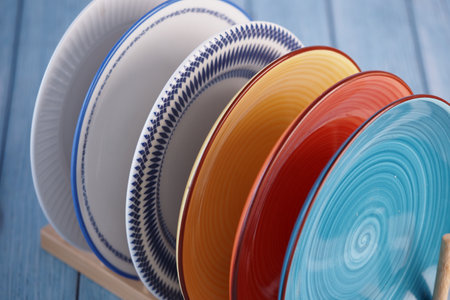Colorful decorative plates arranged on a wooden display standの写真素材