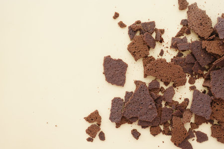 Crumbled chocolate cake pieces strewn on a light surface