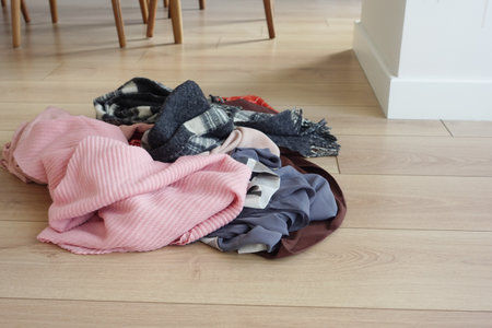 Colorful pile of scarves on wooden floor in cozy living spaceの写真素材