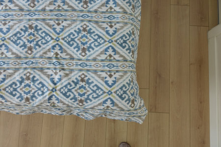 Decorative blanket on a wooden floor with a unique patternの写真素材