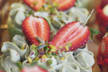 Delicious green tea cupcakes topped with fresh strawberries and nutsの写真素材