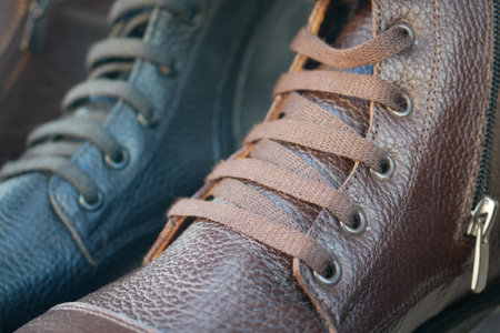 Laces neatly tied on brown and black leather shoes displayed in a shopの写真素材