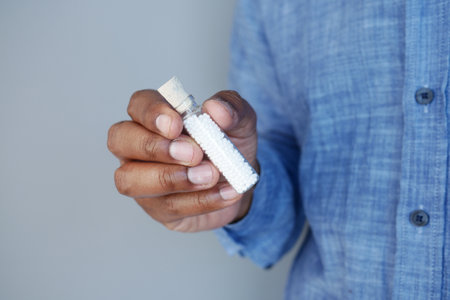 Person holding a small glass bottle with Homeopathy alternative medicineの写真素材