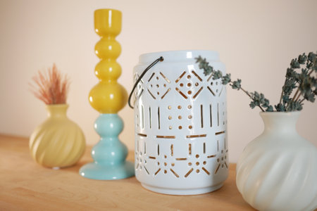 Decorative vases and lanterns arranged on a wooden tabletopの写真素材