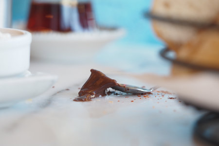 Chocolate spread spilled on table with baked goods in backgroundの写真素材
