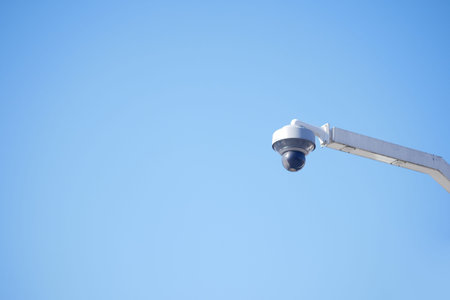 Security camera observes clear blue sky in urban area