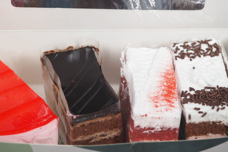 Assorted slices of colorful cakes displayed in a box