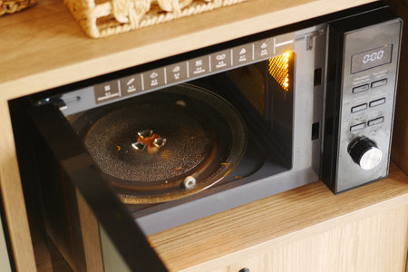 Microwave in use with food heating inside at home kitchenの写真素材