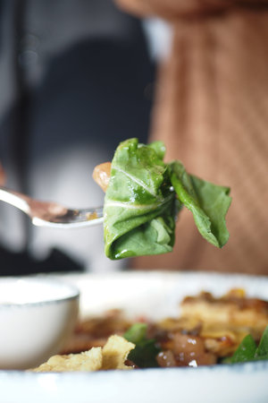 Eating fresh greens at a cozy restaurant during lunchtime