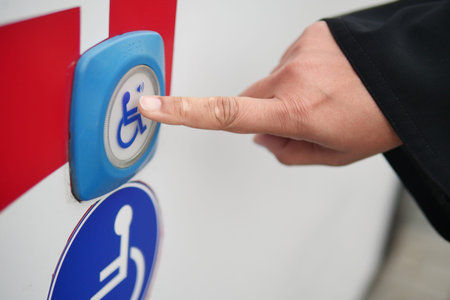 Hand pressing accessibility button on vehicle for assistance