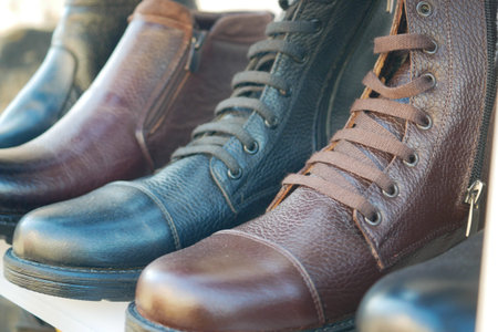 Stylish boots displayed at an outdoor market in bright sunlight