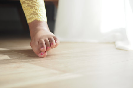 Barefoot stepping on wooden floor in bright settingの写真素材