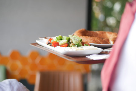 Freshly prepared plate with salad and bread in a cozy cafe setting