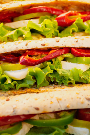 Fresh vegetable sandwiches stacked on a wooden tableの写真素材