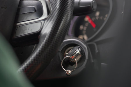 Close-up of car ignition and steering wheel at a roadside stopの写真素材