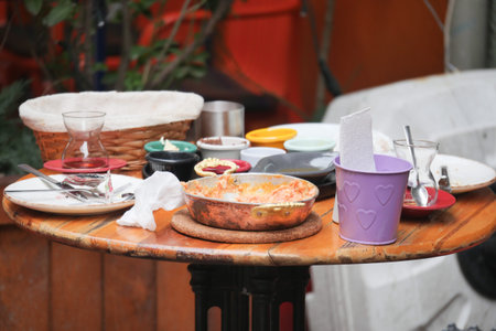 Table with leftover plates and utensils at an outdoor cafe settingの写真素材