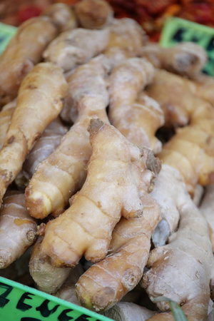 Fresh ginger roots displayed at a local market stall in morning lightの写真素材