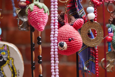 Colorful handmade keychains and accessories displayed in a marketの写真素材