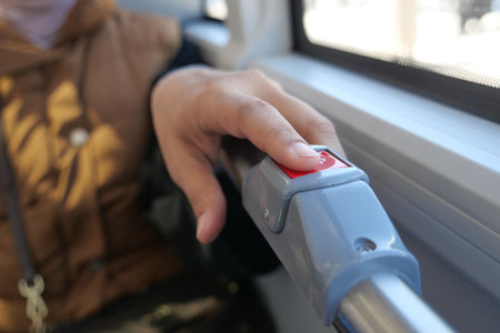 Hand pressing button inside public transportation vehicleの写真素材