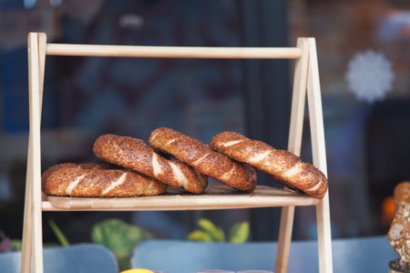 Freshly baked turkish simit displayed on a wooden shelf at a local bakery