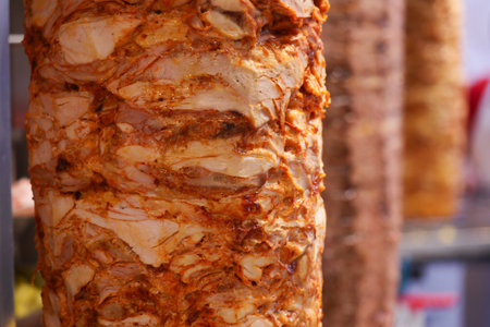 Juicy shawarma meat cooking on rotating spit at a street food stallの写真素材