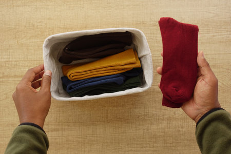 Organizing colorful socks in a fabric storage basket at homeの写真素材
