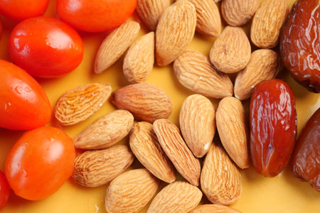Colorful assortment of nuts and dates on a yellow backgroundの写真素材