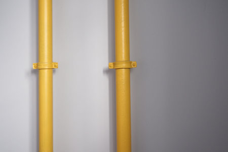 Bright yellow pipes against a neutral background in minimal setting