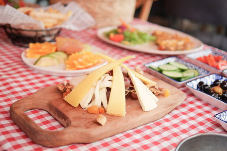 Delicious cheese platter served at outdoor dining area in summerの写真素材