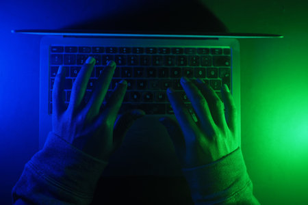 hacker Hands working on a laptop, cyber crime concept