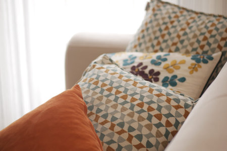 Decorative pillows arranged on a cozy couch in a bright room
